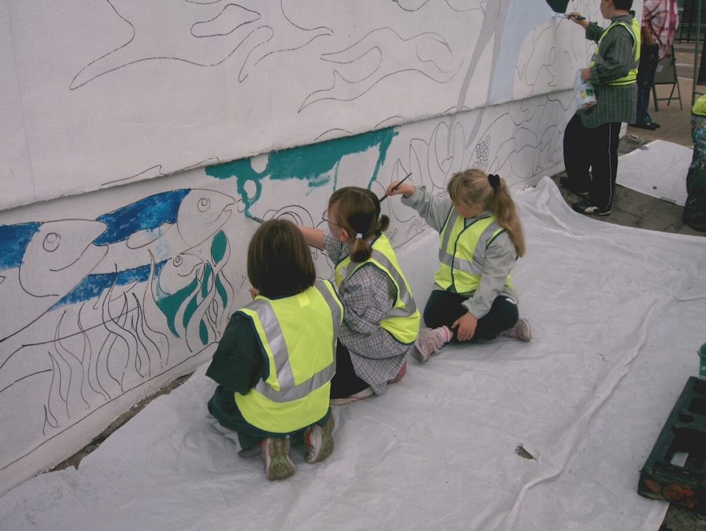 Children helping to paint Our Legacy